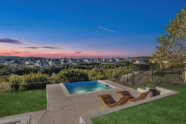 pool at dusk with a yard and a patio area