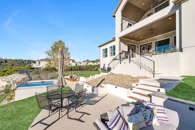 view of patio / terrace with a fenced in pool, a balcony, and ceiling fan