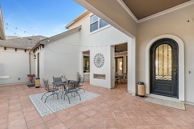 view of patio / terrace with a lit fireplace and outdoor dining space