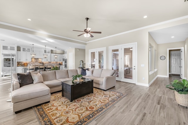 living room with french doors, crown molding, vaulted ceiling, ceiling fan, and light hardwood / wood-style floors