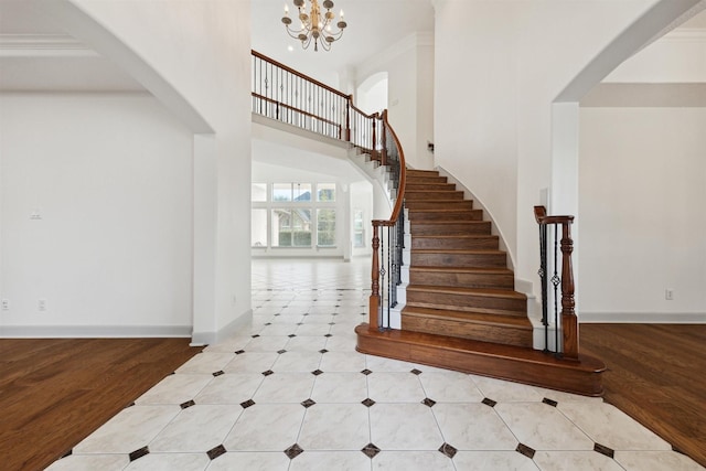 staircase with crown molding, a chandelier, and hardwood / wood-style flooring