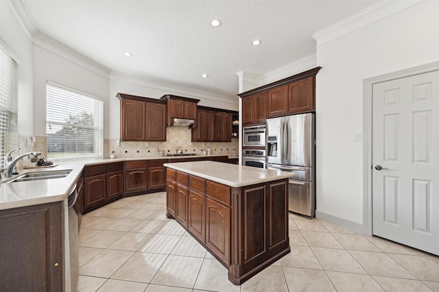 kitchen featuring dark brown cabinetry, sink, a center island, stainless steel appliances, and decorative backsplash