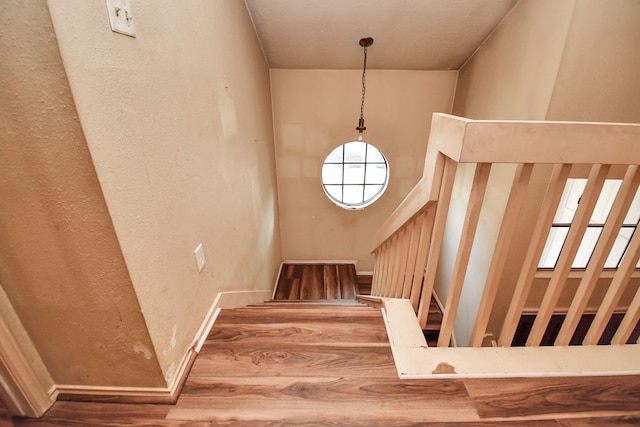 stairs featuring a high ceiling and wood-type flooring