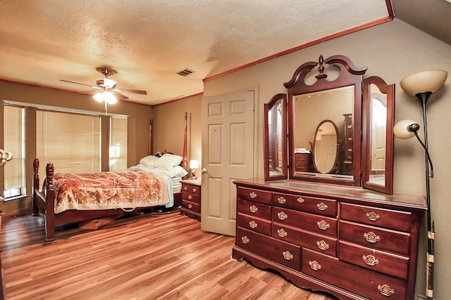 bedroom featuring ceiling fan, light wood-type flooring, a textured ceiling, and ornamental molding