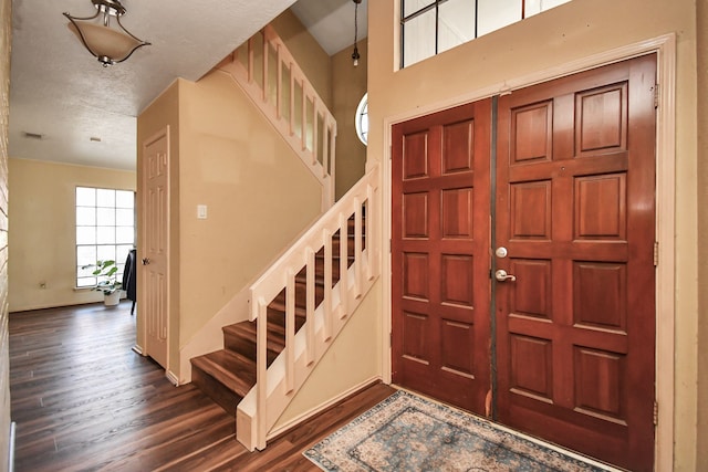 entrance foyer with dark hardwood / wood-style flooring and a textured ceiling