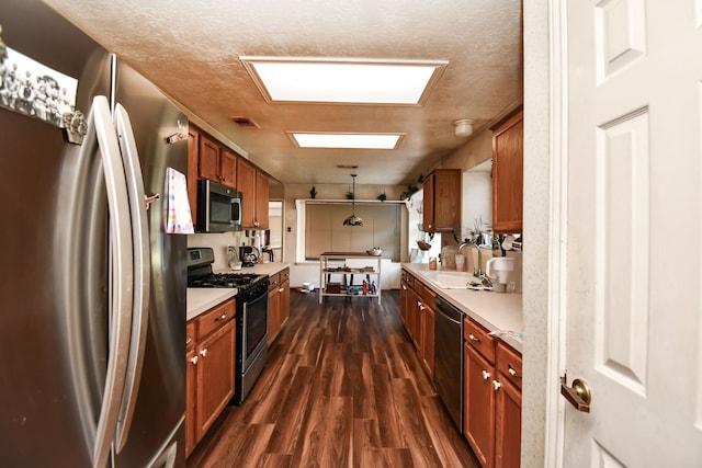 kitchen with dark hardwood / wood-style flooring, sink, stainless steel appliances, and a textured ceiling