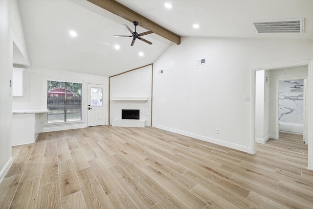 unfurnished living room featuring ceiling fan, a fireplace, beamed ceiling, and light hardwood / wood-style floors