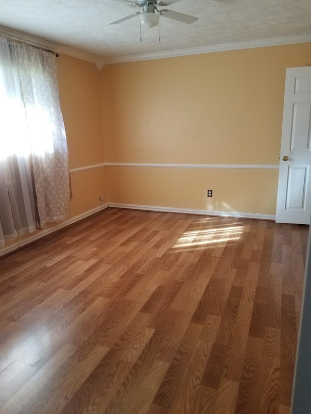 unfurnished room featuring a textured ceiling, hardwood / wood-style flooring, and ornamental molding