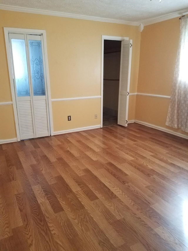 unfurnished bedroom with light hardwood / wood-style flooring, multiple windows, and crown molding