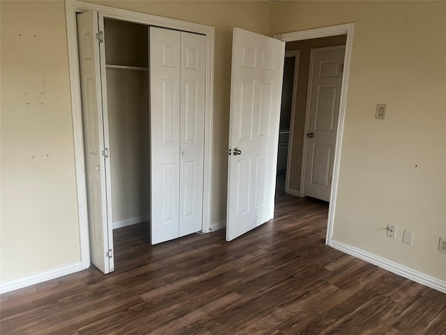 unfurnished bedroom featuring dark wood-type flooring and a closet