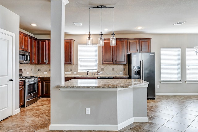 kitchen with light stone countertops, stainless steel appliances, tasteful backsplash, pendant lighting, and a kitchen island