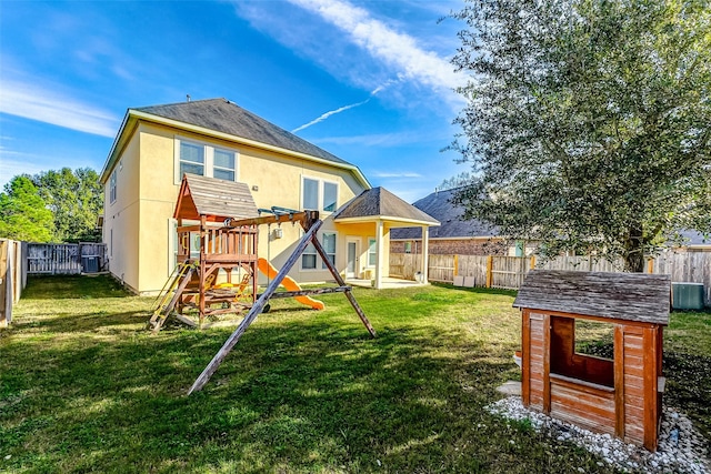 back of house with a lawn, a storage unit, cooling unit, and a playground