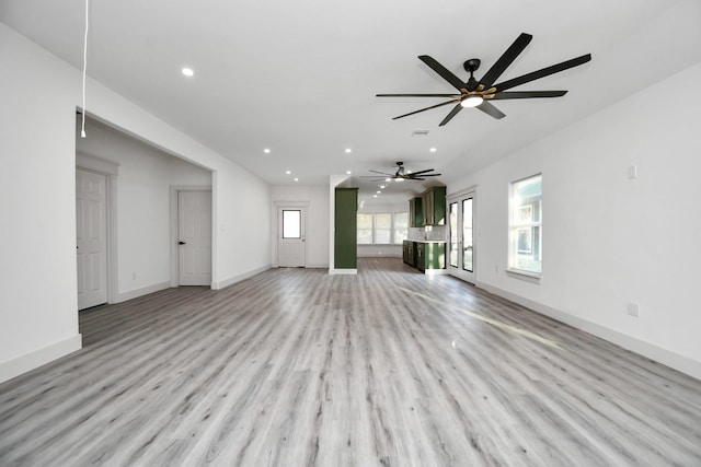 unfurnished living room featuring ceiling fan and light wood-type flooring