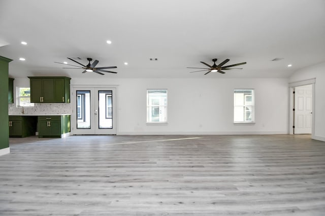 unfurnished living room featuring french doors, light hardwood / wood-style flooring, a wealth of natural light, and sink