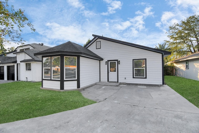 rear view of property featuring a lawn