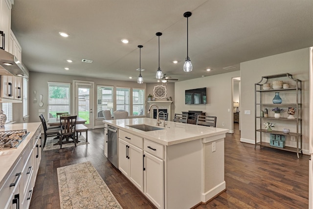 kitchen featuring pendant lighting, white cabinetry, an island with sink, and appliances with stainless steel finishes