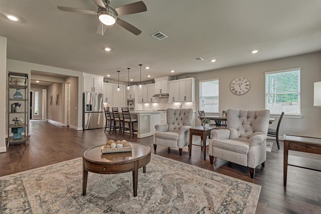 living room featuring ceiling fan and dark hardwood / wood-style flooring