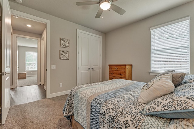 bedroom featuring ceiling fan, a closet, and light carpet