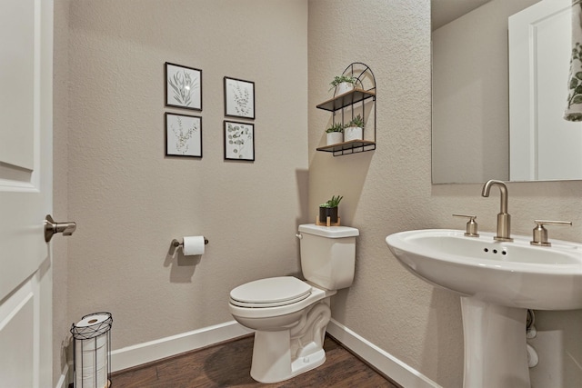 bathroom featuring wood-type flooring, toilet, and sink