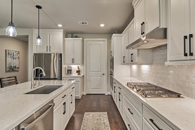 kitchen with sink, white cabinetry, stainless steel appliances, and hanging light fixtures