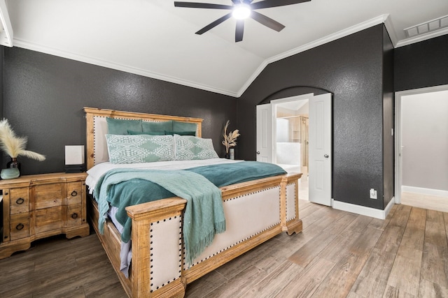 bedroom with ceiling fan, ensuite bathroom, hardwood / wood-style floors, vaulted ceiling, and ornamental molding