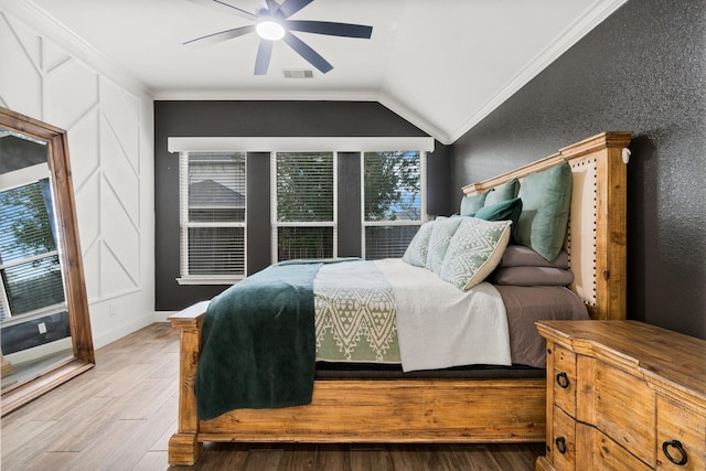 bedroom with hardwood / wood-style floors, ceiling fan, lofted ceiling, and crown molding