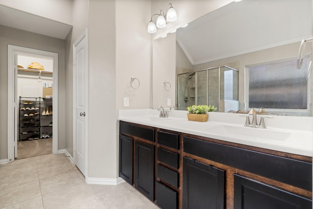 bathroom featuring walk in shower, tile patterned floors, vaulted ceiling, vanity, and ornamental molding