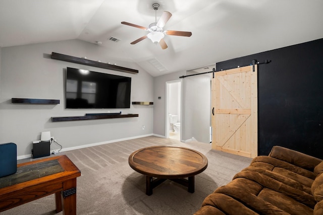 carpeted living room with a barn door, vaulted ceiling, and ceiling fan