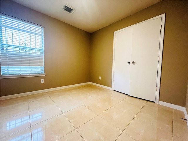 unfurnished bedroom with a closet and light tile patterned flooring