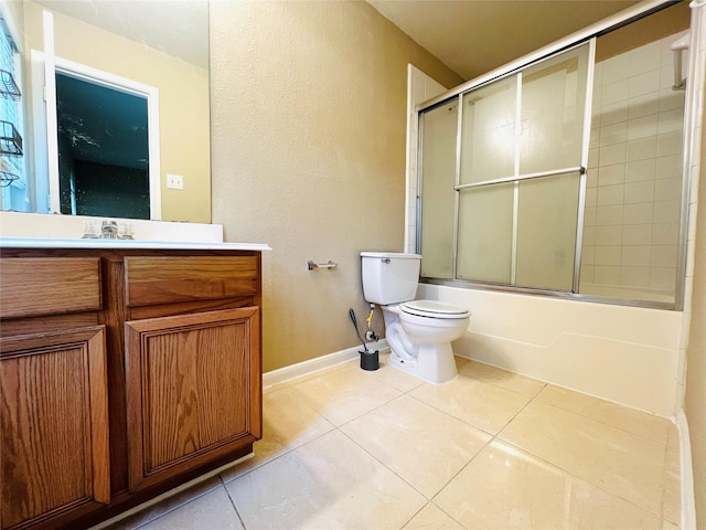 full bathroom featuring vanity, combined bath / shower with glass door, tile patterned floors, and toilet