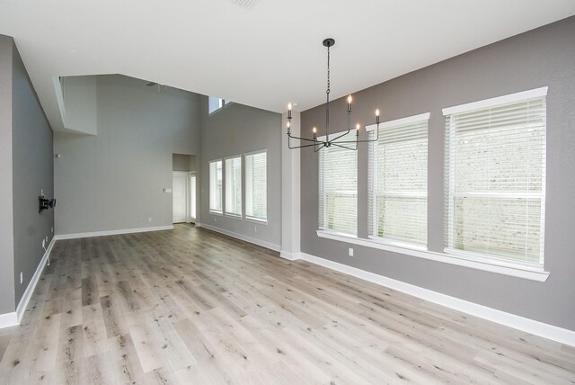 unfurnished dining area featuring light hardwood / wood-style floors and a notable chandelier