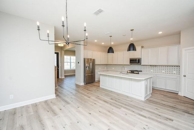 kitchen featuring white cabinets, a kitchen island with sink, and appliances with stainless steel finishes