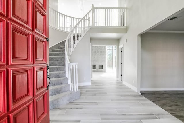 foyer entrance featuring ornamental molding and light hardwood / wood-style flooring