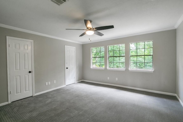 spare room featuring dark colored carpet, ceiling fan, and crown molding