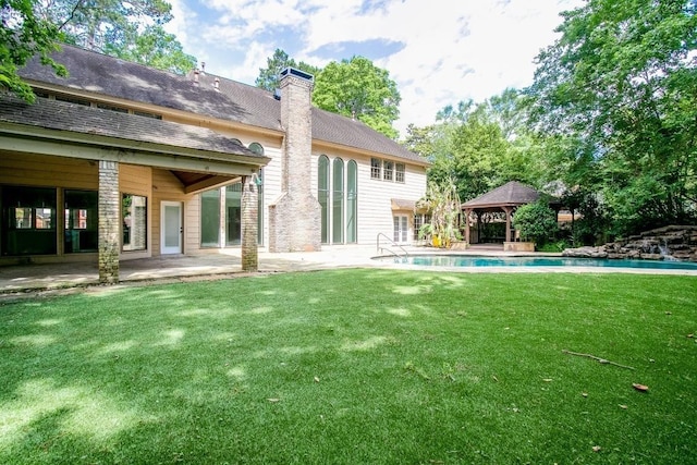 rear view of property featuring a gazebo, a patio area, and a yard