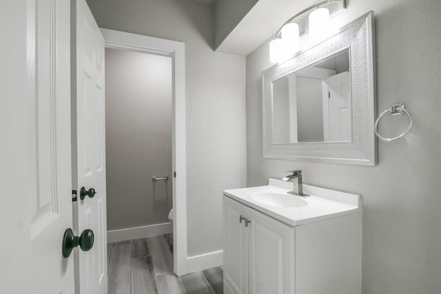 bathroom with vanity, hardwood / wood-style flooring, and toilet