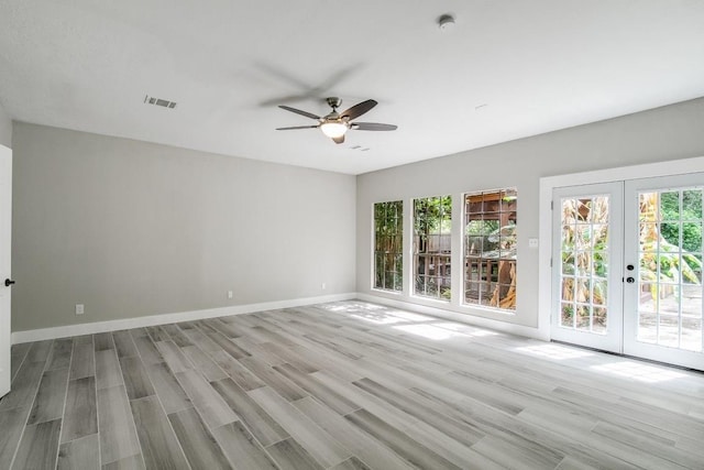 unfurnished room with ceiling fan, french doors, and light wood-type flooring