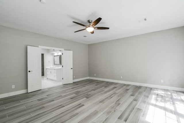 unfurnished bedroom with light wood-type flooring, connected bathroom, and ceiling fan