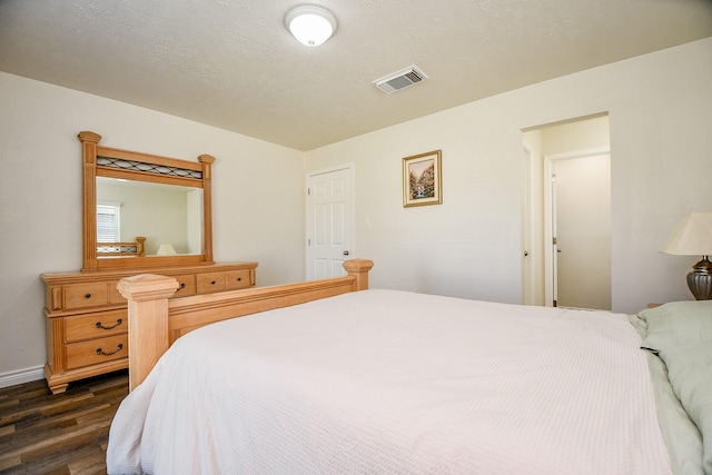 bedroom featuring a textured ceiling and dark wood-type flooring