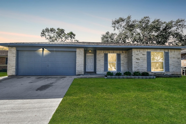 view of front of home featuring a garage and a lawn