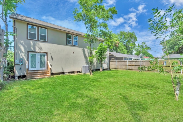 back of house featuring a lawn, french doors, and central air condition unit