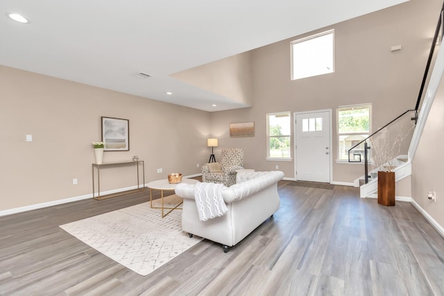 living room with light hardwood / wood-style flooring and a high ceiling