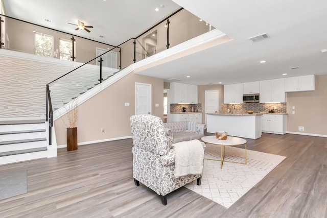 living room with ceiling fan and wood-type flooring