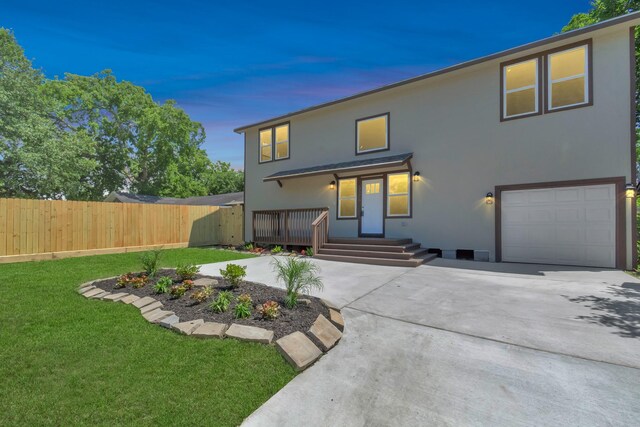 back house at dusk featuring a lawn and a garage