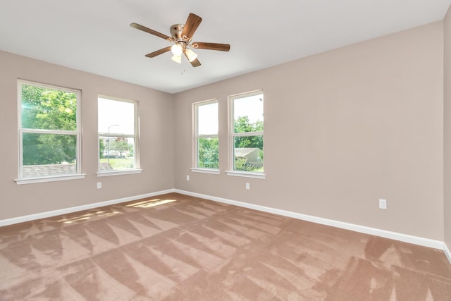 empty room with ceiling fan and light carpet