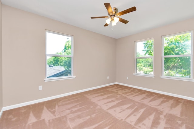 empty room featuring plenty of natural light, ceiling fan, and light colored carpet