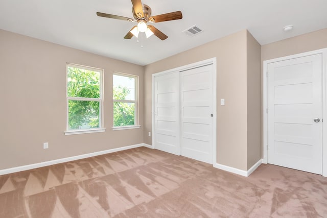 unfurnished bedroom with ceiling fan, a closet, and light colored carpet