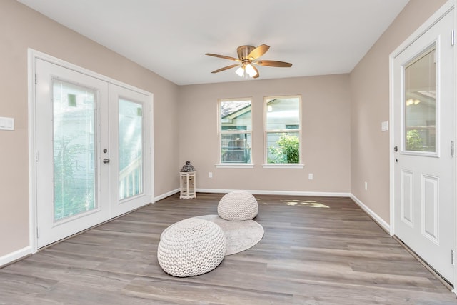 living area featuring ceiling fan, french doors, and light hardwood / wood-style floors