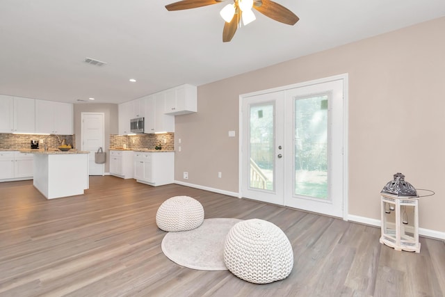 kitchen featuring white cabinetry, light hardwood / wood-style floors, and decorative backsplash