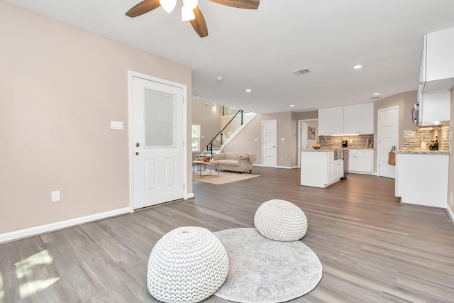 living room with light hardwood / wood-style floors and ceiling fan